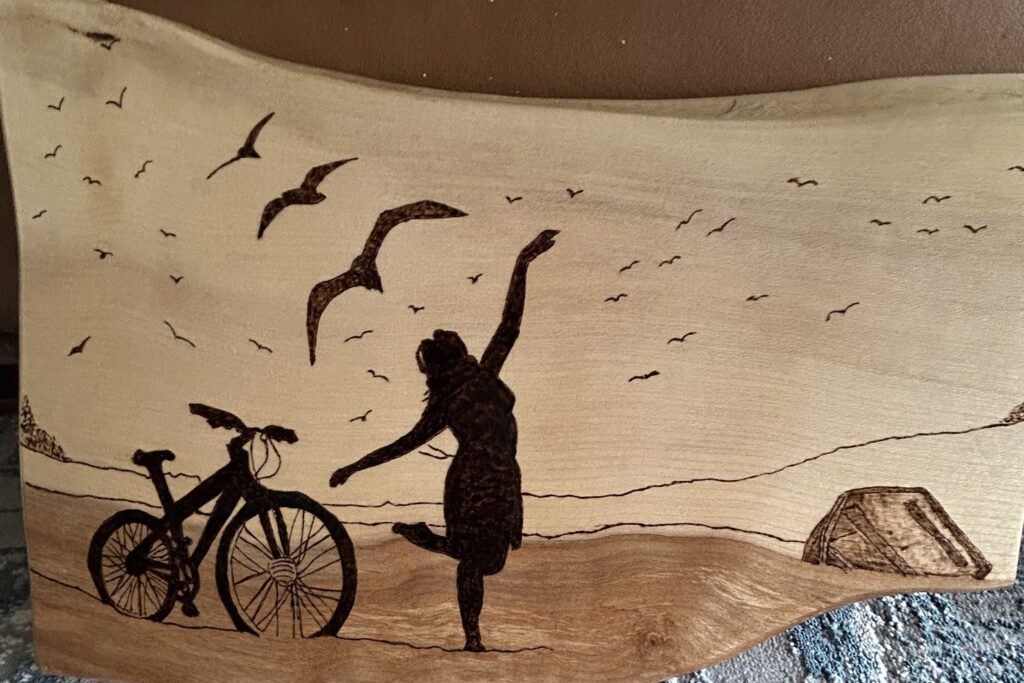 Pyrography-drawing-girl-and-bike-at-the-seaside